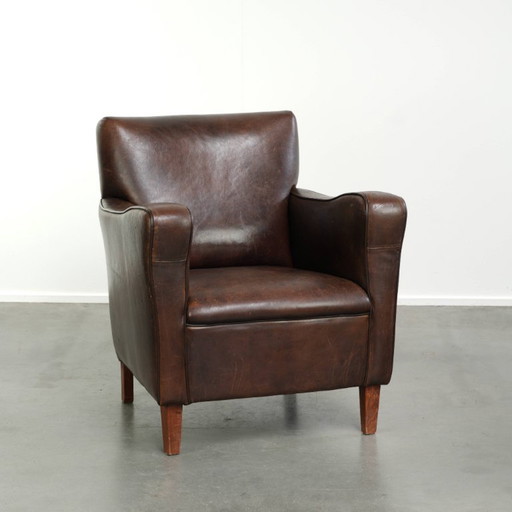 Fauteuil vintage robuste en cuir de mouton avec belle patine et design anglais intemporel de taille subtile