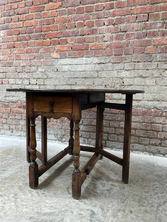 Image 1 of Tavolo antico in rovere con gambe a ribalta e cassetto