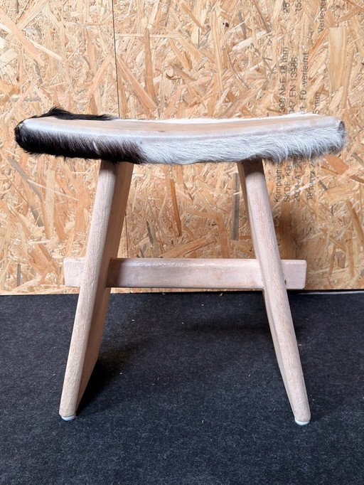 Taburete tapizado en piel de vaca.