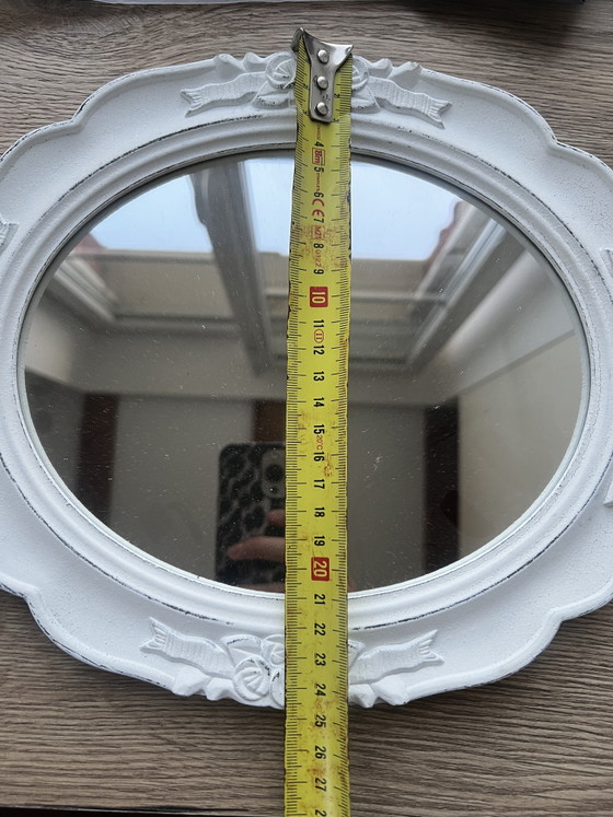 Image 1 of Specchio ovale in legno bianco con intagli floreali.