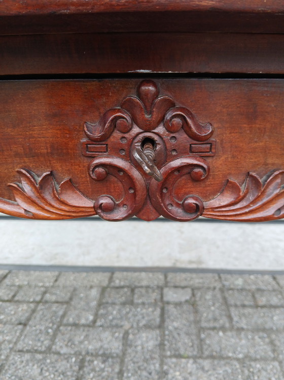Image 1 of The antique dining table is made of mahogany and has a Louis XV style.