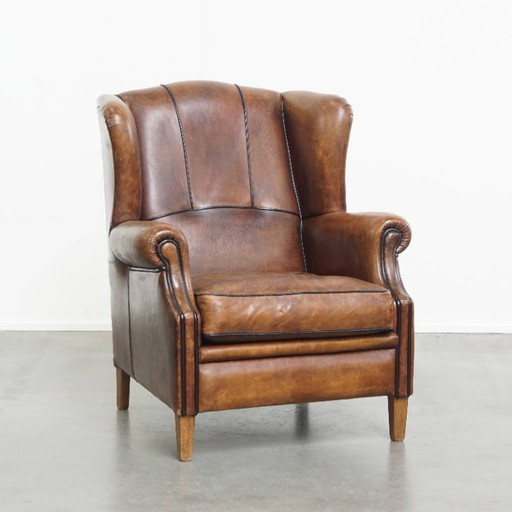Fauteuil à oreilles en cuir de mouton avec finition passepoilée noire