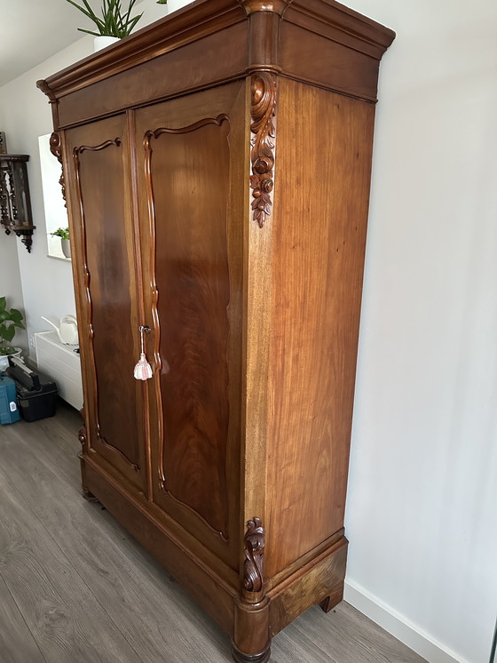 Image 1 of Armario antiguo de madera con detalles ornamentales.