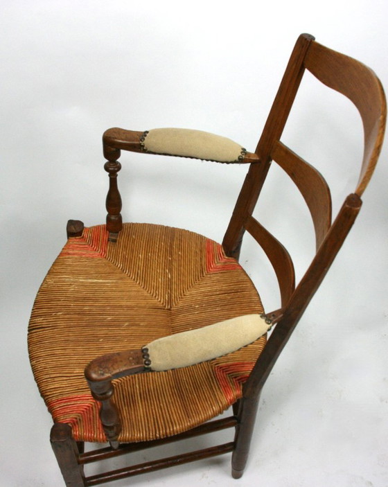 Image 1 of Antieke Frans-Provençaalse armstoel met biezenmat zitting — notenhout, gedraaide accenten, circa late 19e/vroeg 20e eeuw