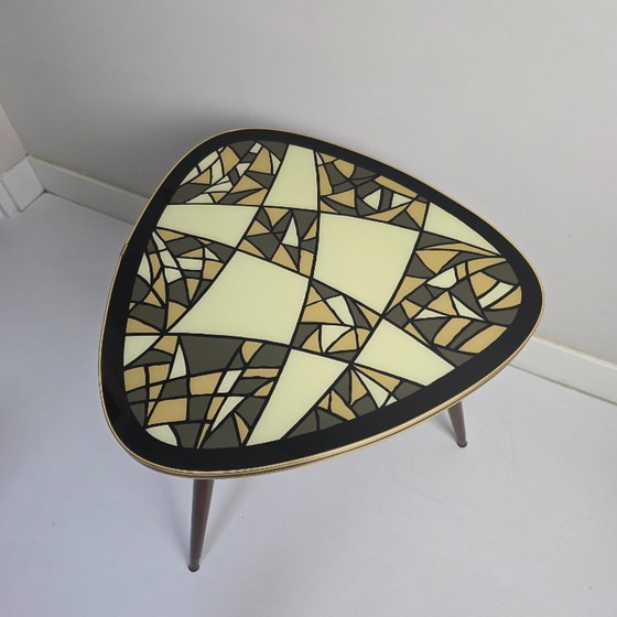 Image 1 of Tavolino da caffè vintage. Triangolare, a tre gambe, a forma di "rene". Piano in vetro con motivo retrò. Anni '50/'60.