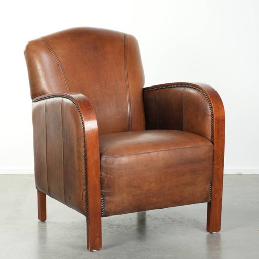 Beautiful sheepskin armchair in Art Deco style with wooden armrests