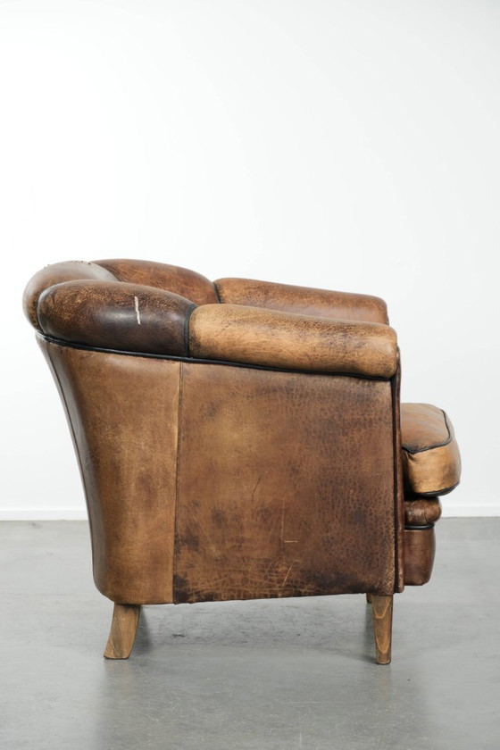 Image 1 of Leuke vintage schapenleren clubfauteuil in Engelse stijl met zwarte biezen