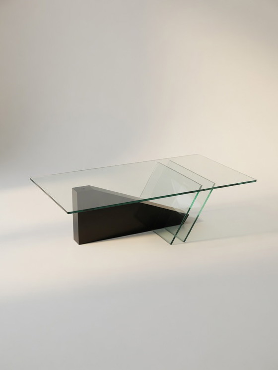Image 1 of italiaanse Jaren 80 postmoderne salontafel met een zwarte houten basis en een glazen blad.