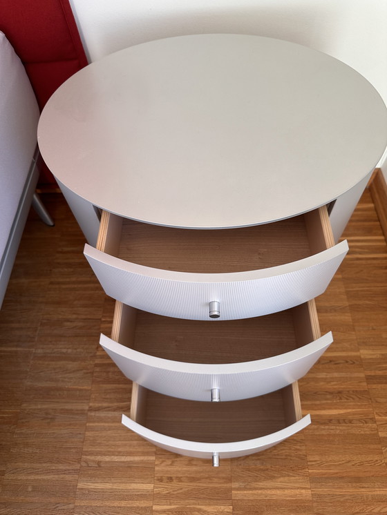 Image 1 of Comodino ovale in legno massello con rivestimento in alluminio spazzolato opaco