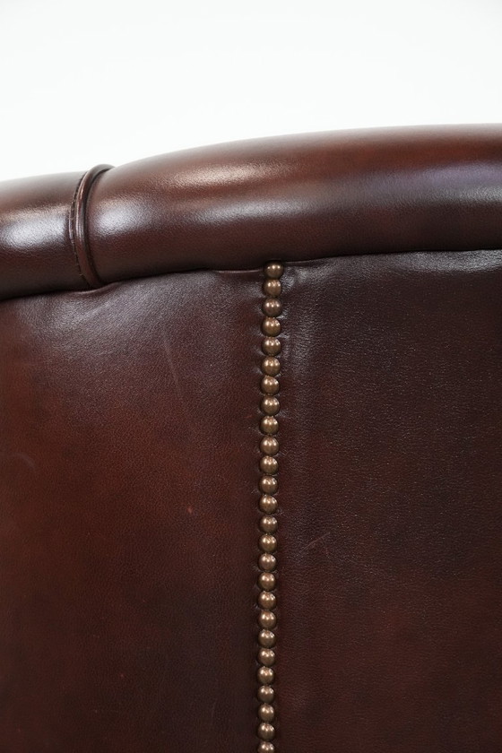 Image 1 of Sillón club de piel de vaca en buen estado, de un lujoso color rojo/marrón.