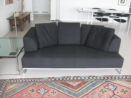 B&B Italia 2,5 zits bank met antracietkleurige stoffen bekleding en RVS onderstel.