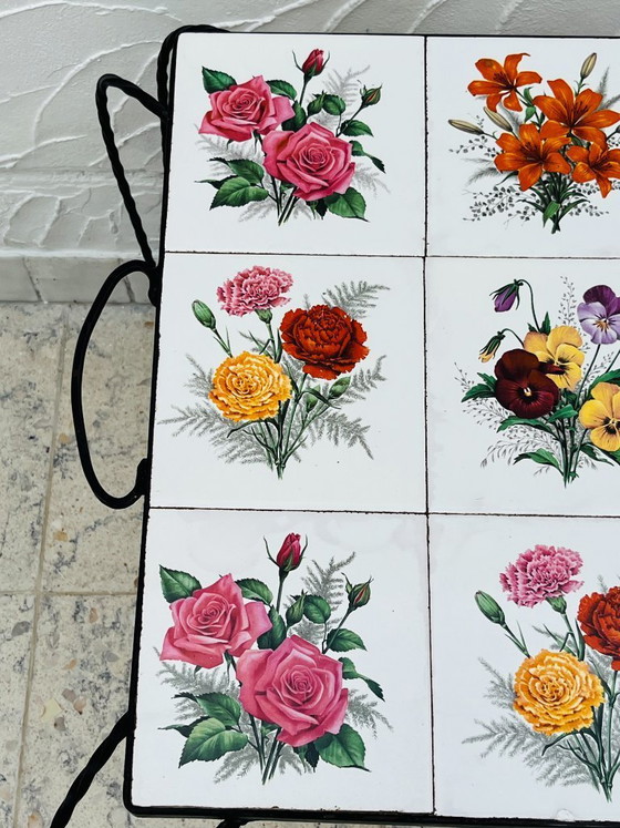 Image 1 of Vintage salontafel van smeedijzer met bloemmotief op de tegels.