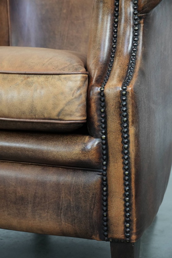 Image 1 of Clubfauteuil gemaakt van schapenleer afgewerkt met siernagels