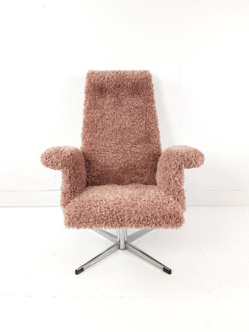 Fauteuil pivotant vintage, récemment retapissé de tissu rose à motifs.