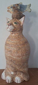 Escultura de cerámica de un gato con compañeros de juego.