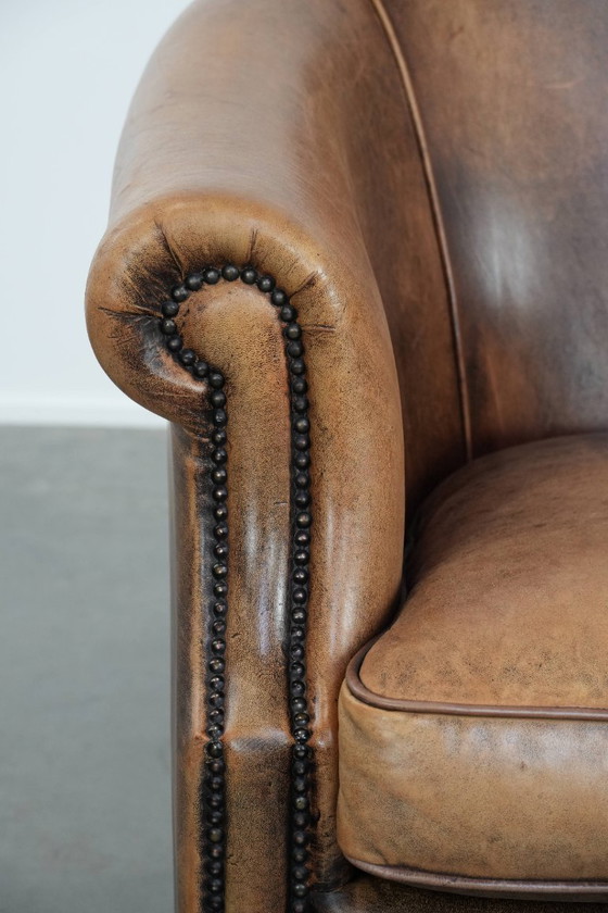Image 1 of Clubfauteuil gemaakt van schapenleer afgewerkt met siernagels