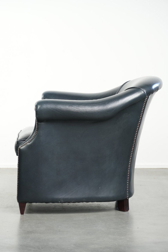 Image 1 of Bellissima e confortevole poltrona club in pelle bovina blu scuro dal design unico e senza tempo.