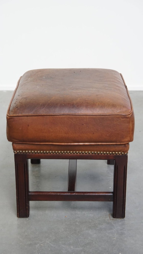 Image 1 of Hocker in pelle di pecora con struttura in legno e finitura con rivetti decorativi