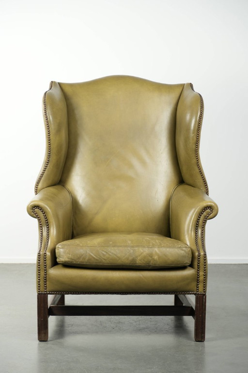 Fauteuil à oreilles ancien et élégant en cuir de vachette vert, de style classique de maison de campagne anglaise.