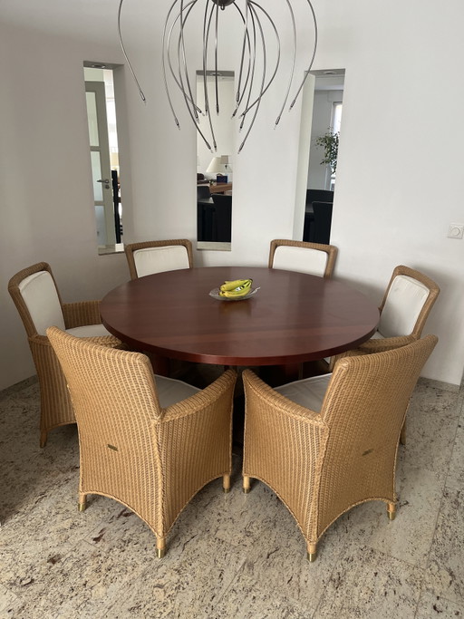 Solid cherry wood round table with beautiful matching Lloyd Loom chairs.