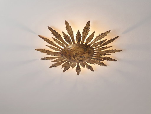 Plafondlamp met verguld metalen ontwerp in de vorm van een zonnestraal met bladmotieven, uit het midden van (photo 2 of 9)