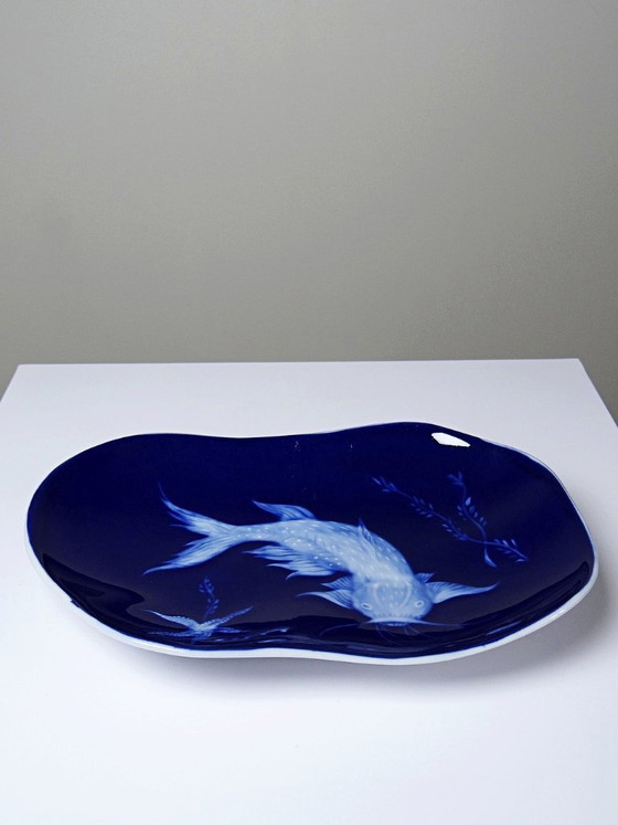 Image 1 of Plato pequeño de porcelana de Limoges con esmalte azul y decoración de peces al estilo japonés.