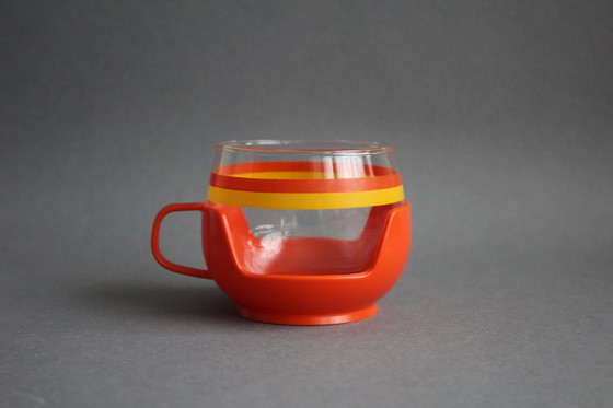 Image 1 of 12 vintage glazen theekopjes met geel-oranje strepen en oranje plastic houders.