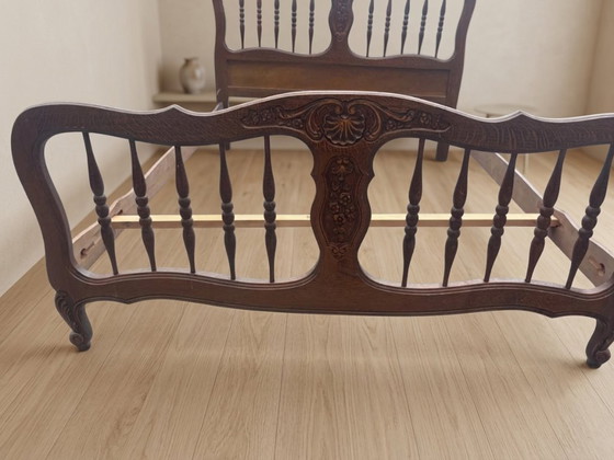 Image 1 of Vintage houten bedframe met houtsnijwerk, sierlijk hoofd- en voetbord, eerste helft 20e eeuw