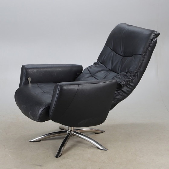 Image 1 of Modernist black leather armchair with a chrome X-frame base in a contemporary style, in good condition with minor signs of aging
