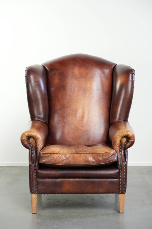 Comfortabele rundleren oorfauteuil in Engelse stijl met een prachtige warme kleurstelling en een karaktervolle uitstraling