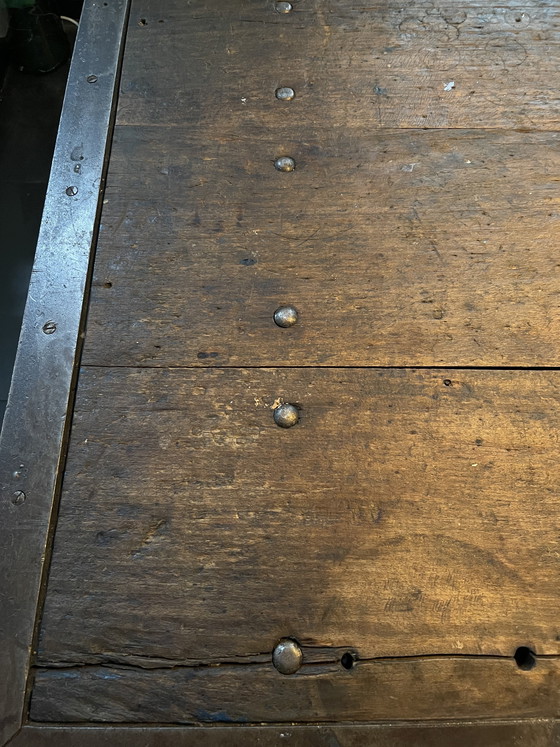 Image 1 of Industriele eettafel van oude werkbank met gietijzer onderstel y gelaste randen