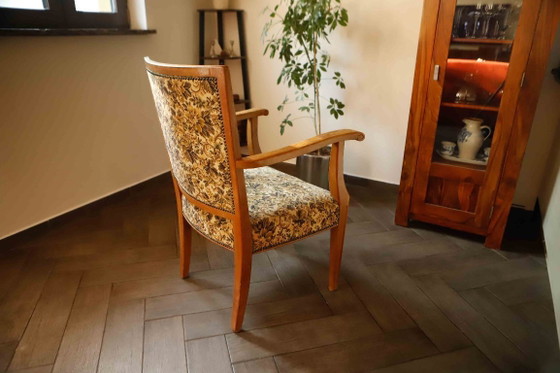 Image 1 of Vintage salonfauteuil met bloemenpatroon op de bekleding en sierlijke armleuningen.