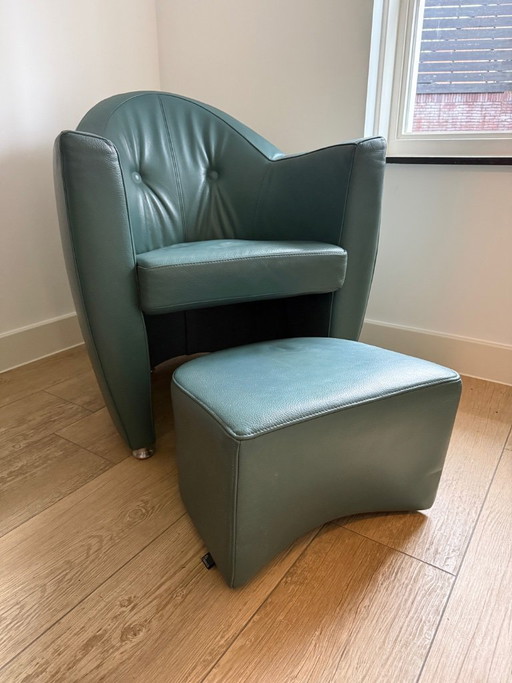 Sillón Leolux Carabita con otomana, tapizado en piel verde oliva.