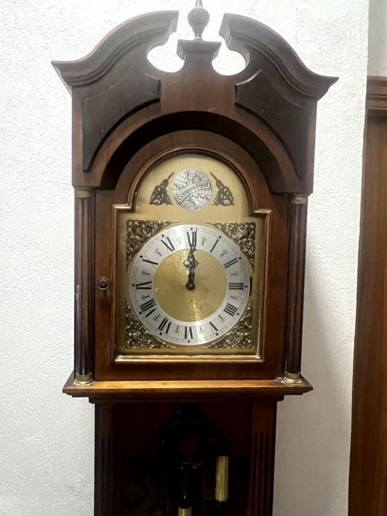 Image 1 of Eine hölzerne Pendeluhr mit einem Schweizer mechanischen Uhrwerk