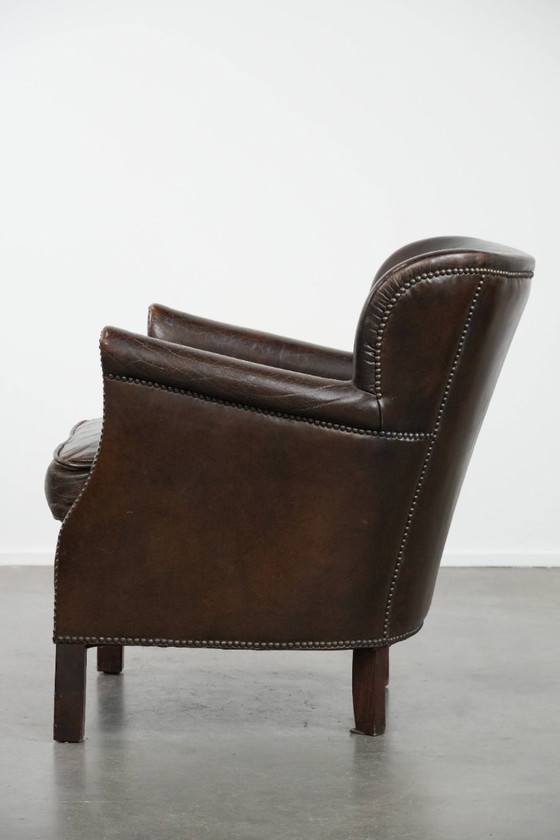 Image 1 of Subtiele donkerbruine fauteuil gemaakt van rundleer met een omkeerbaar Kelim zitkussen