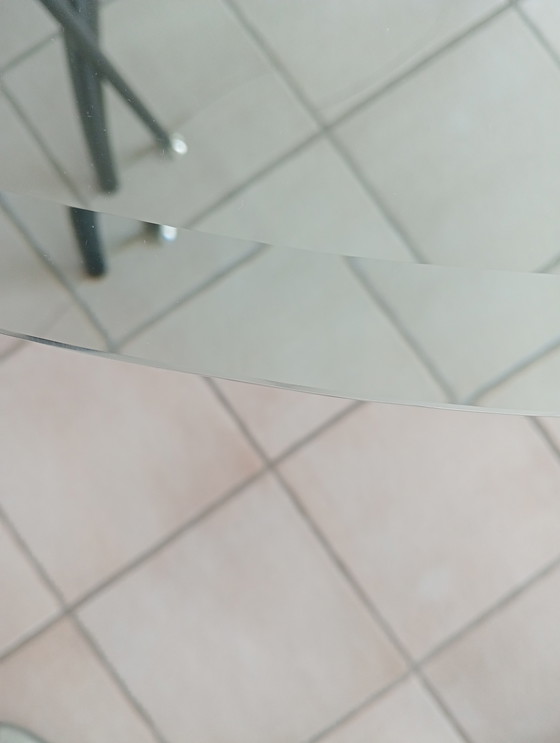 Image 1 of Mesa de comedor ovalada de cristal con 4 sillas negras a juego.