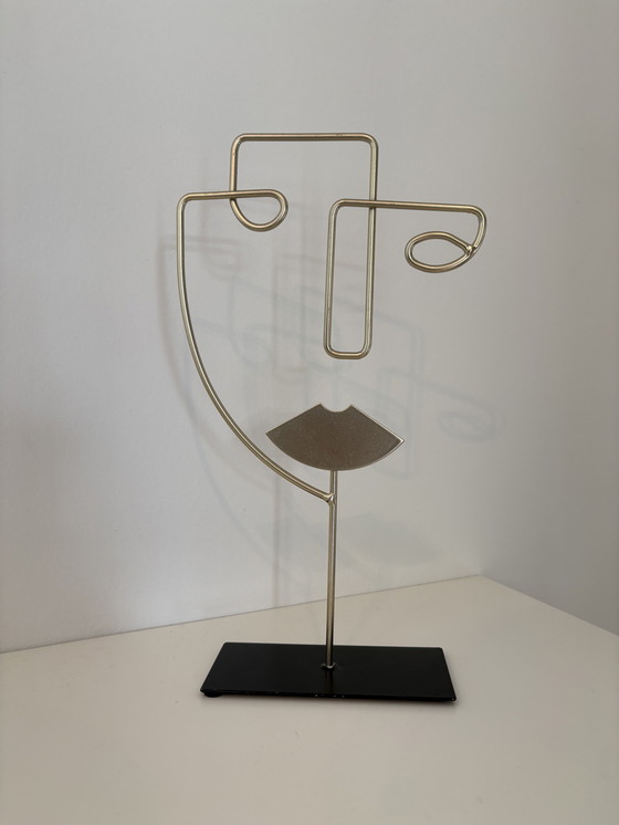 Image 1 of Scultura moderna in filo metallico raffigurante un volto stilizzato, di colore oro