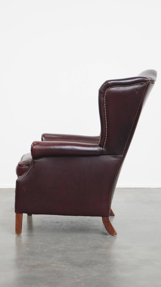 Image 1 of Bordeauxrode Rundleren Oorfauteuil in Engelse Stijl