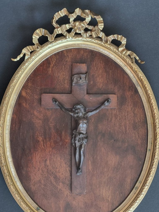 Elegant wandkruisbeeld, ovale gouden lijst met lintversiering, antiek kruisbeeld van Jezus