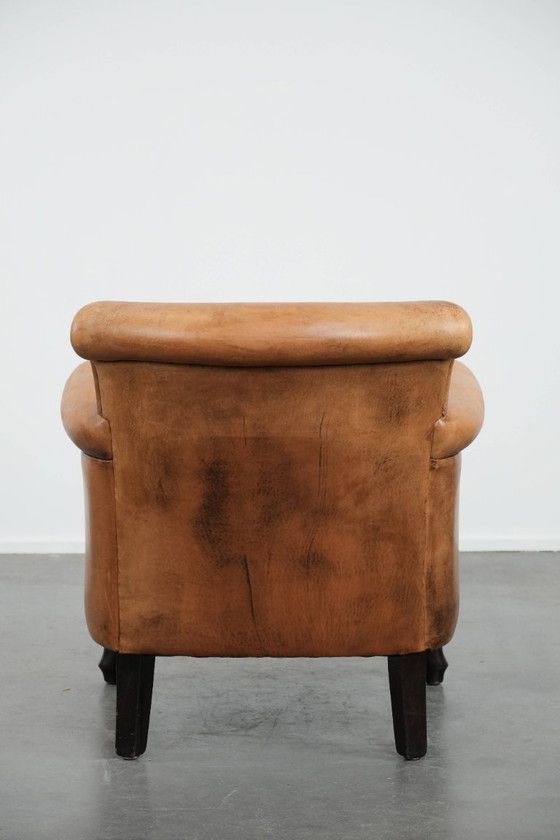 Image 1 of Fauteuil vintage discret en peau de mouton aux pieds gracieux