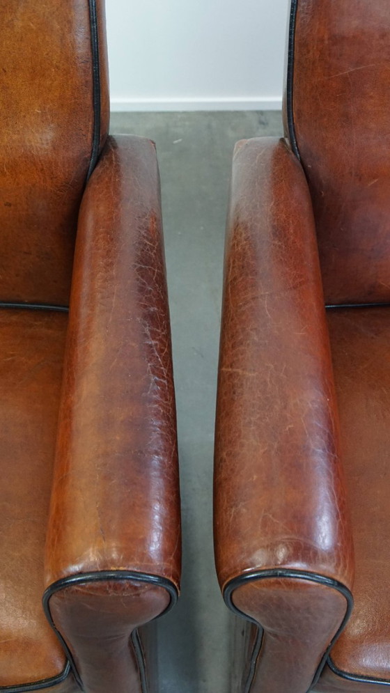 Image 1 of 4 x Vintage schapenleren eetkamerstoel met zwarte biezen op wieltjes