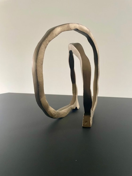 Image 1 of Escultura de diseño con forma de anillo abierto en oro mate.