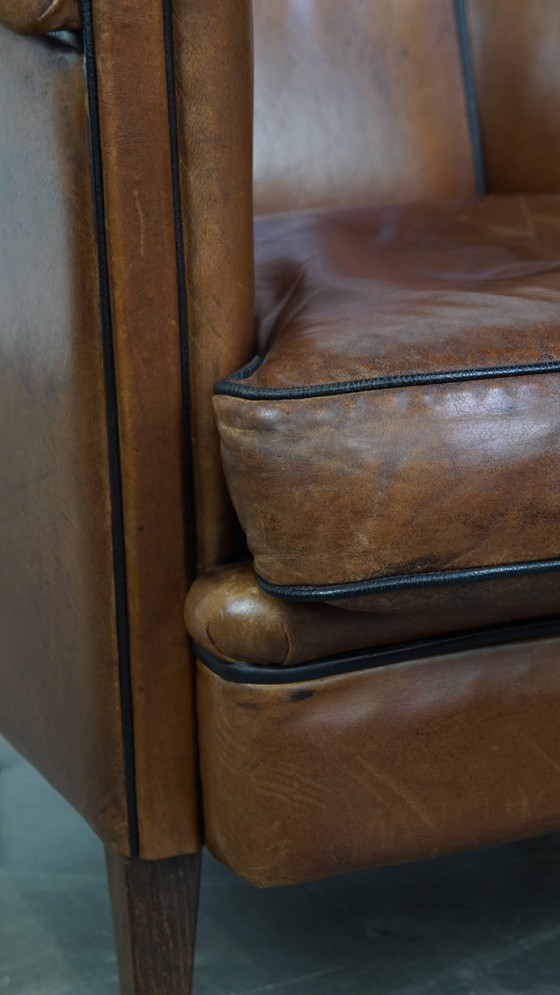 Image 1 of Unieke vintage cognac kleurige lederen clubfauteuil met een afwerking met zwarte biezen