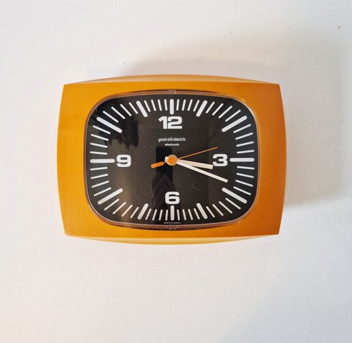 Orangefarbene Vintage-Wanduhr aus den 1970er Jahren, gute alte elektrische Uhr