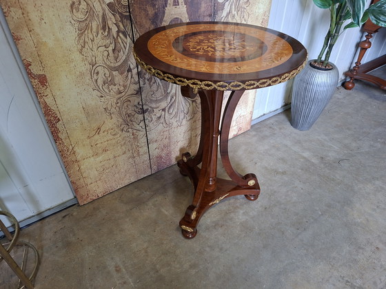 Image 1 of Mesa central redonda clásica de chapa de nogal con marquetería, base ornamentada y herrajes de latón.