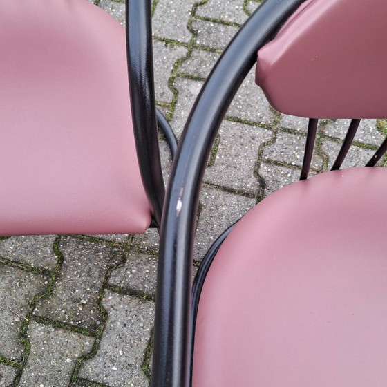 Image 1 of This is a set of four vintage 'Memphis' style chairs with a black metal frame and burgundy upholstery.