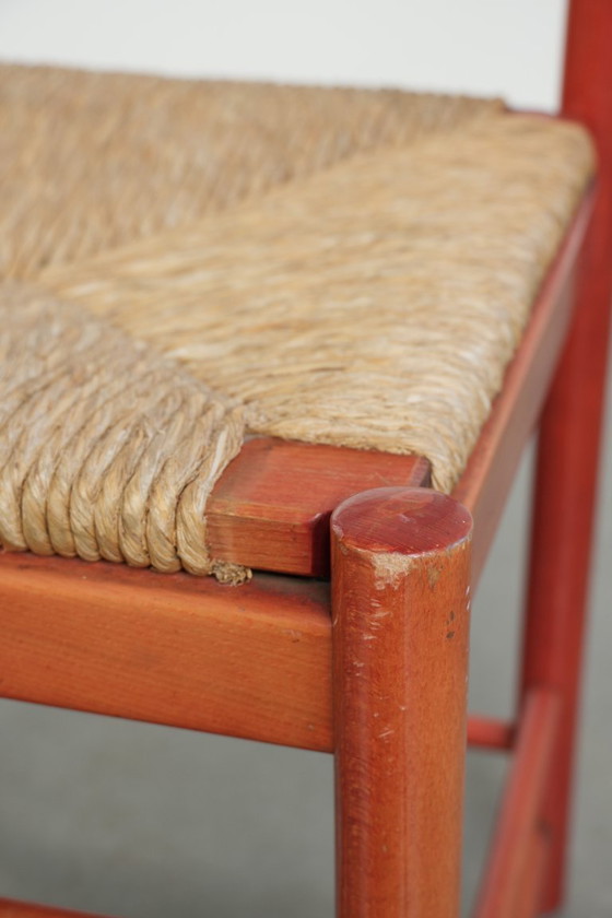 Image 1 of Schöner roter Vintage-Holzstuhl aus den 70er Jahren mit einer Sitzfläche aus geflochtenem Rohrgeflecht.