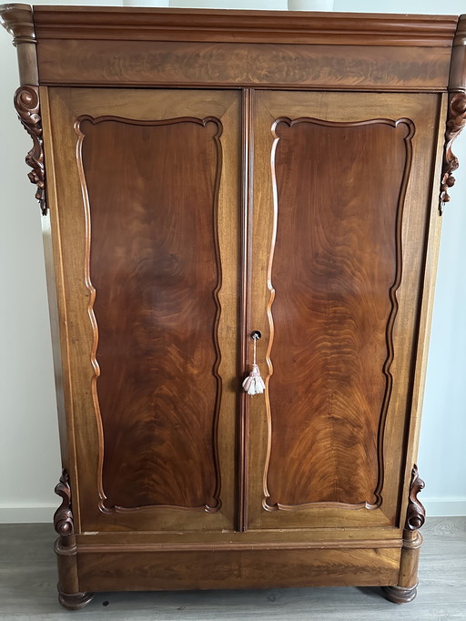 Armario antiguo de madera con detalles ornamentales.