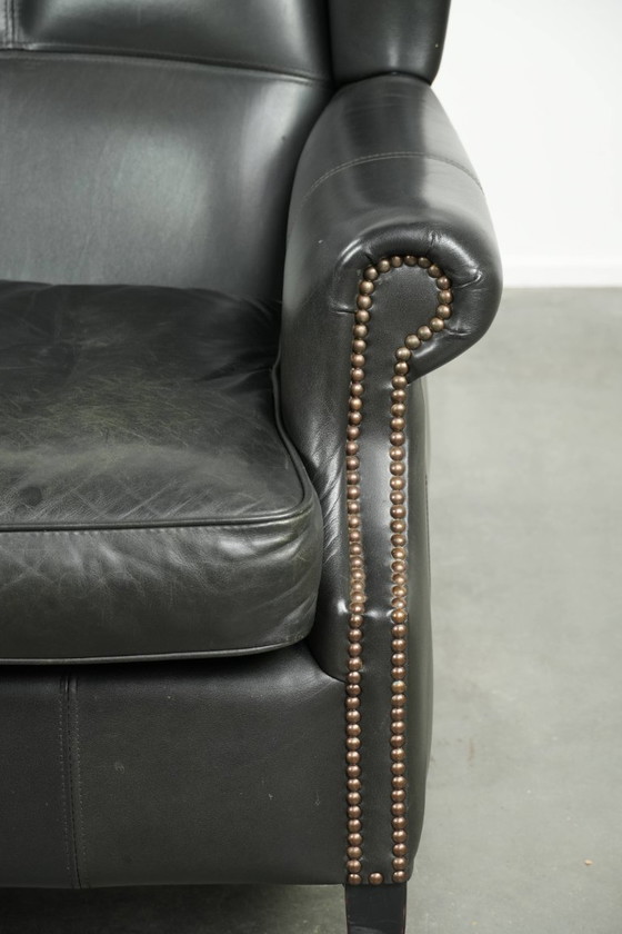 Image 1 of Zwarte rundleren oorfauteuil in een klassiek Engelse stijl