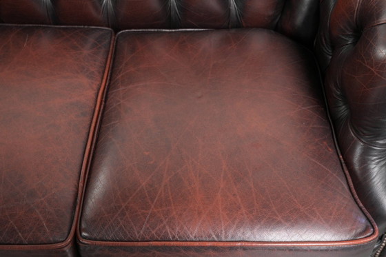 Image 1 of Canapé Chesterfield 2 places en cuir de vachette anglais ancien rouge/marron, au style magnifique et au charme intemporel.